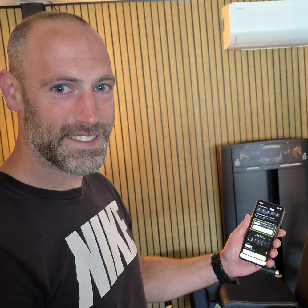 Raymond Bolt, personal trainer, met FORJ op zijn telefoon in de sportschool